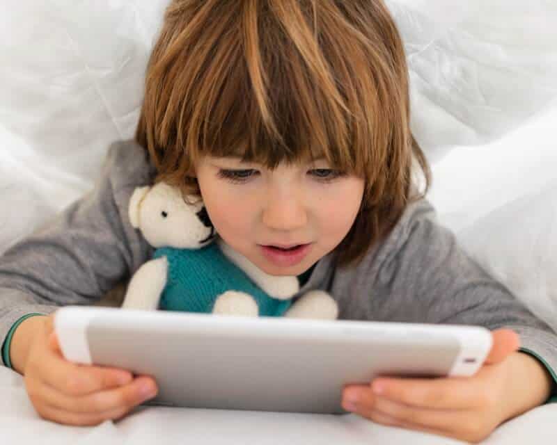 Young boy watching a tablet device very close to his face