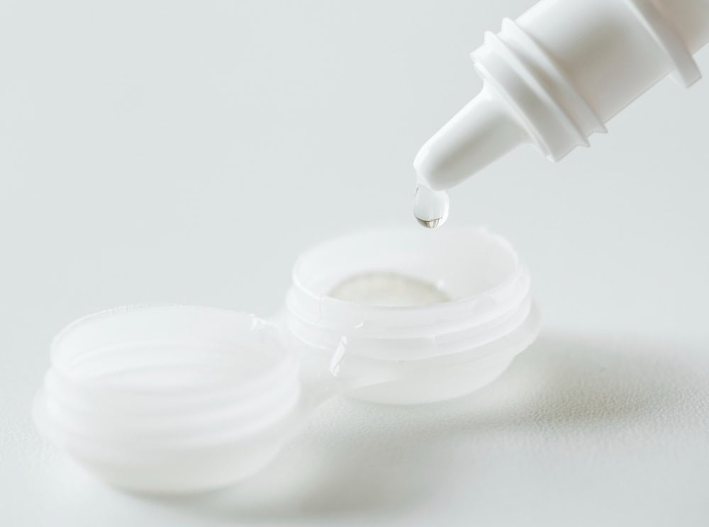 Contact lenses in case on white background